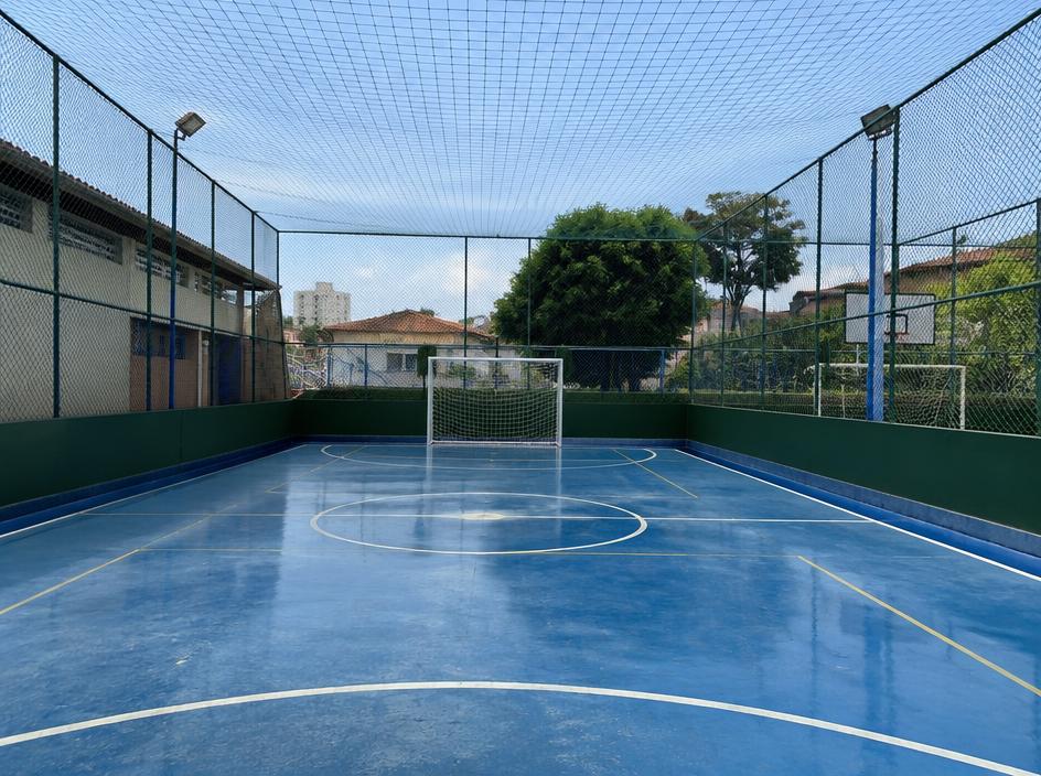 Quadra esportiva com rede de proteção no fechamento e teto